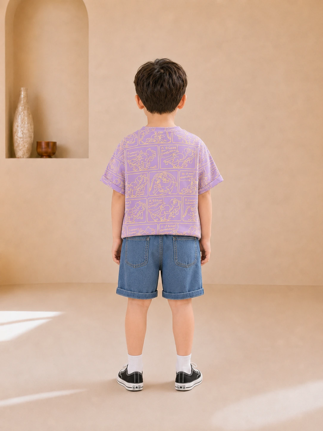 Boy wearing a purple dinosaur-print T-shirt and blue denim shorts