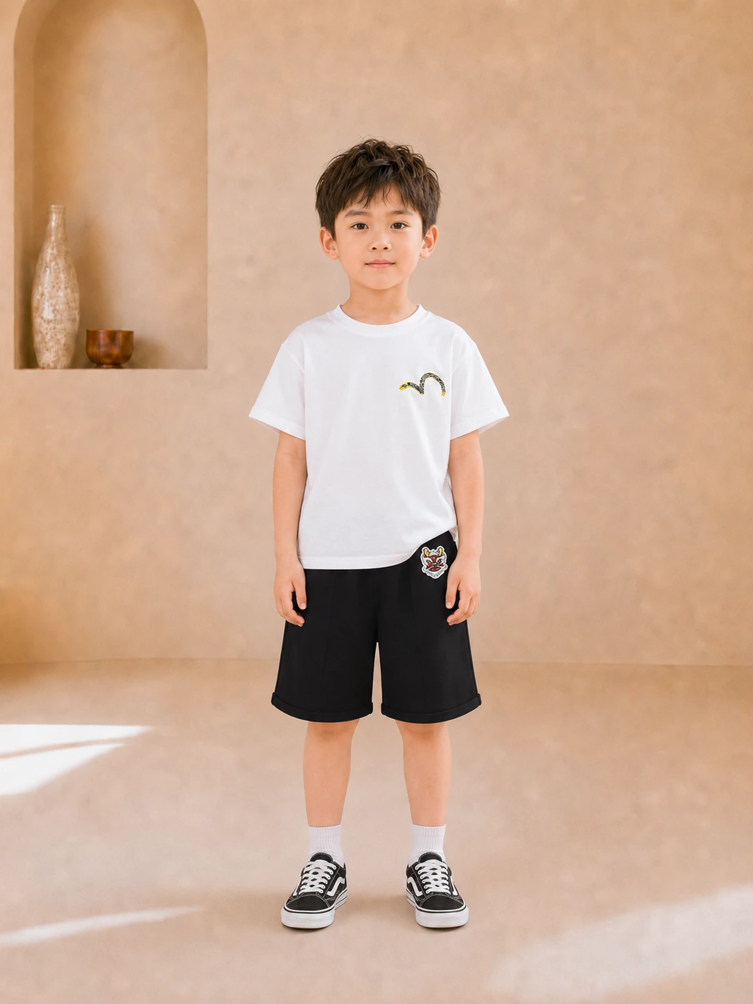 Boy wearing a white graphic T-shirt and black knee-length shorts
