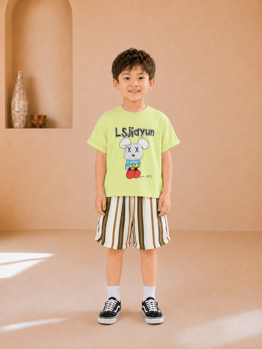 Boy wearing a lime green graphic T-shirt and striped knee-length shorts