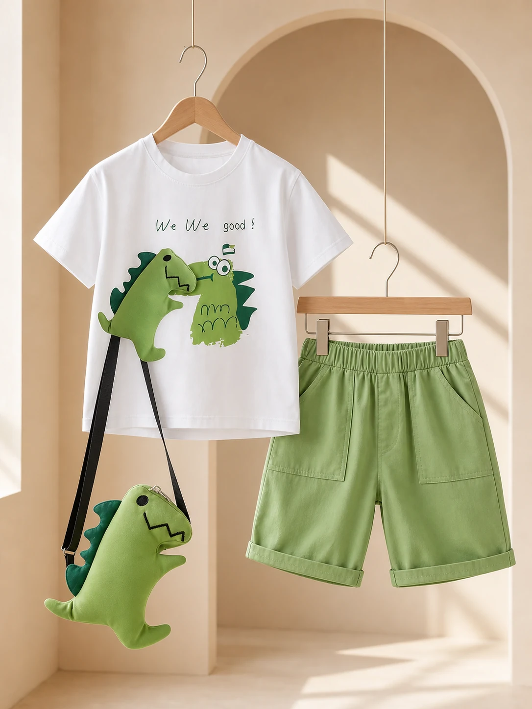 Boy wearing a white dinosaur T-shirt, green shorts and dinosaur crossbody bag